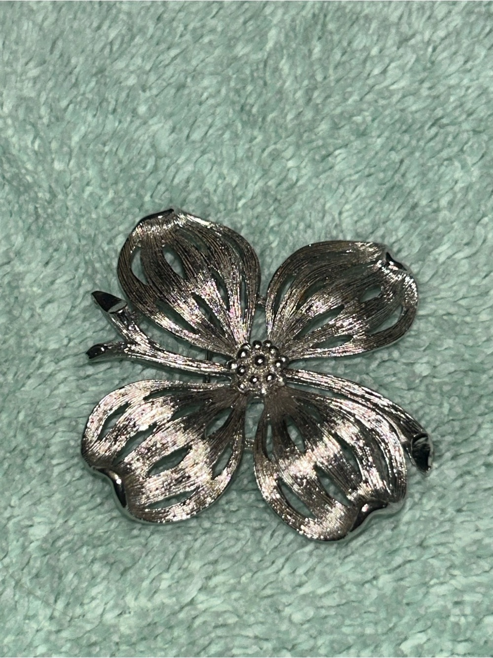 vintage silver-tone metal floral brooch shaped like a four-petal dogwood flower